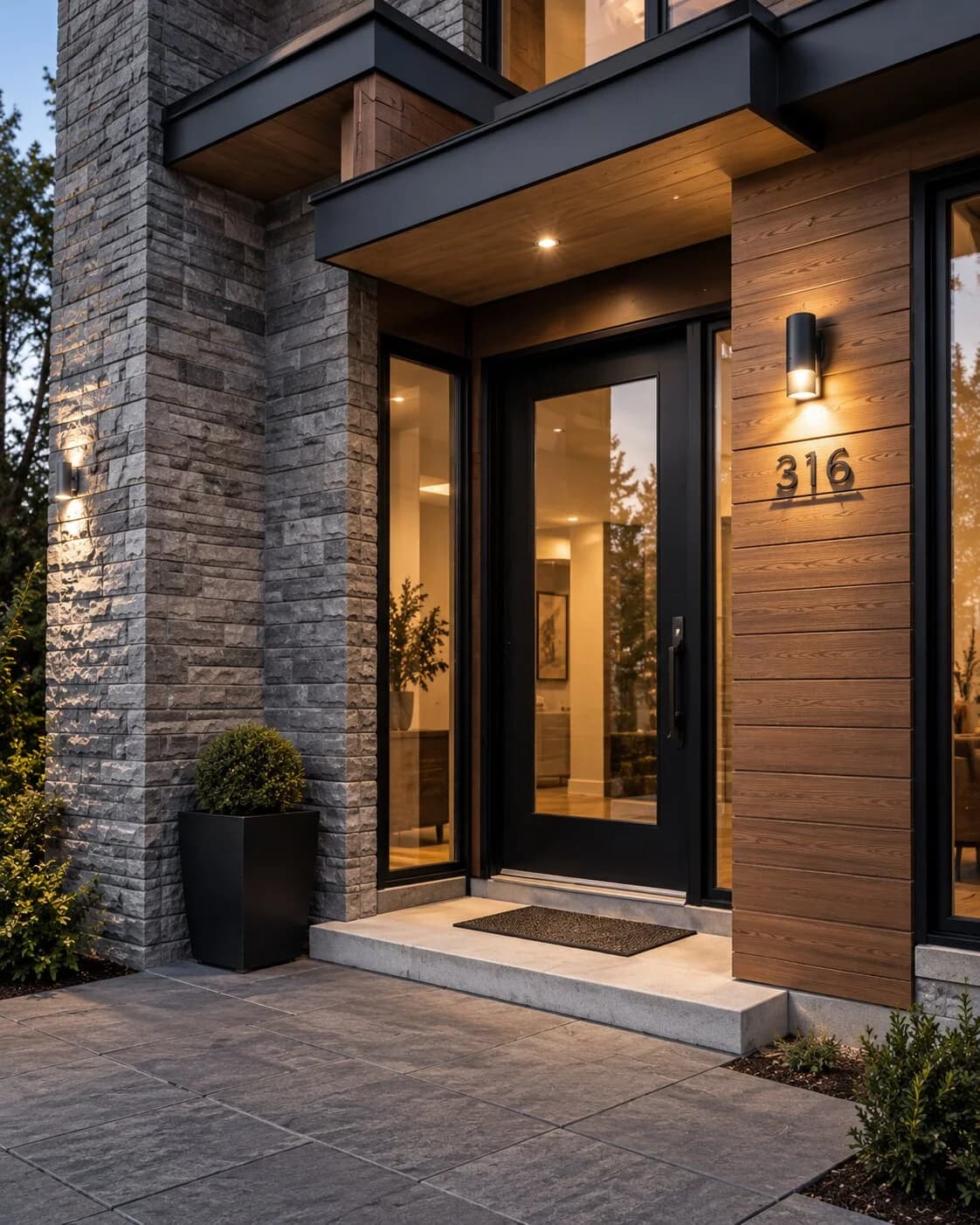Design reference of a stone and timber entrance with a glazed front door and warm lighting
