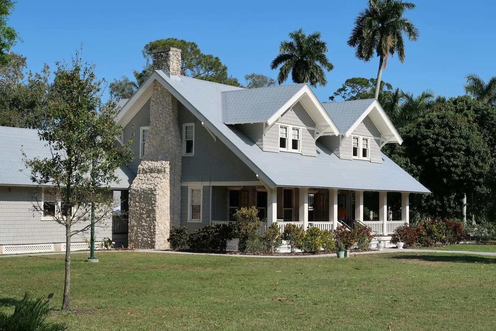 Home exterior design reference with white siding, a covered entrance, and a green front lawn